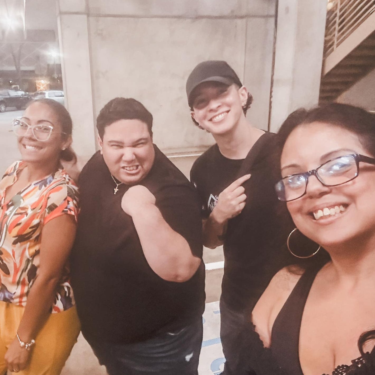 Group of four friends posing together in an urban setting.