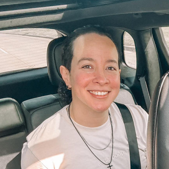 Two women sitting inside a car, smiling at the camera.