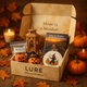 LURE Wellness Box with Halloween-themed items on a wooden surface with pumpkins and leaves.